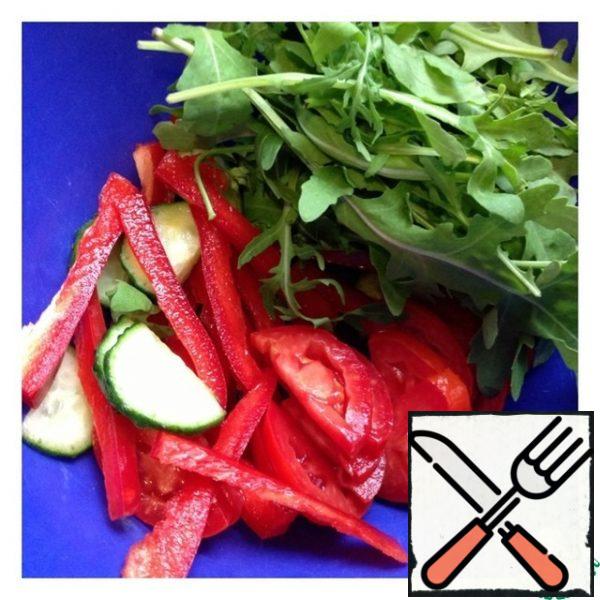 Put the arugula in a salad bowl. Cut cucumber and tomato into slices, pepper into thin strips.