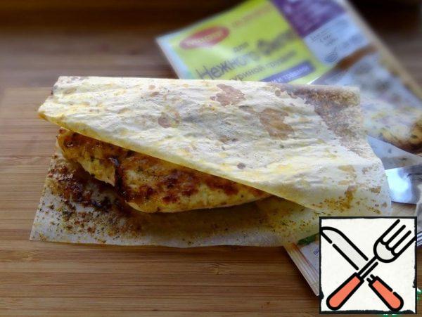 Lightly chop the chicken fillet from the thick edge and fry, using a leaf for a tender fillet with garlic and herbs.