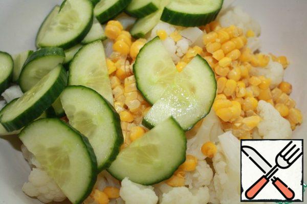 Mix the cabbage, cucumber and corn.
Add the gas station. Mix everything well and let it stand for about 15 minutes.