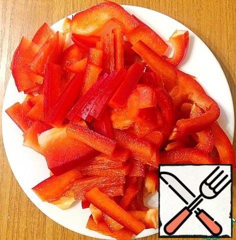 Peel the bell pepper and cut it into thin slices.