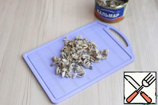Cut the canned squid into small cubes.
