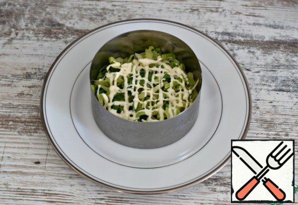Lay out the salad in layers, using a serving ring. Or serve the salad in a common large salad bowl, also laying it out in layers.
The first layer is Peking cabbage. Lightly mash the cabbage. Pour a small amount of dressing.