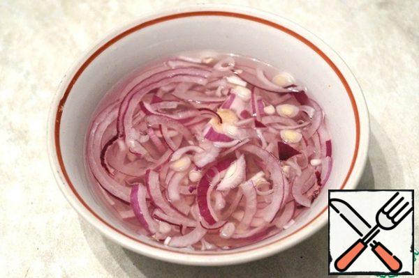 Peel the onion and cut it into thin half-rings. Add sugar, salt, vinegar and 100 ml of water, and mix. Leave for 30 minutes. Then throw it on a sieve, dry it.