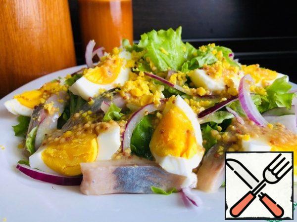 6. Boiled chicken eggs are cut into four parts.
Spread the chopped eggs, herring fillets in a salad bowl.
Before serving, we take out the chilled dressing and pour it over the salad.