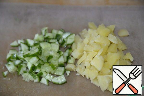 Cut the cucumber and peeled boiled potatoes into small cubes.