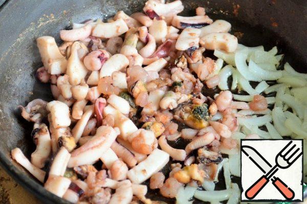 Fry the onion in 1 tablespoon of olive oil,
add the seafood,
fry for 2 minutes, the heat is strong.