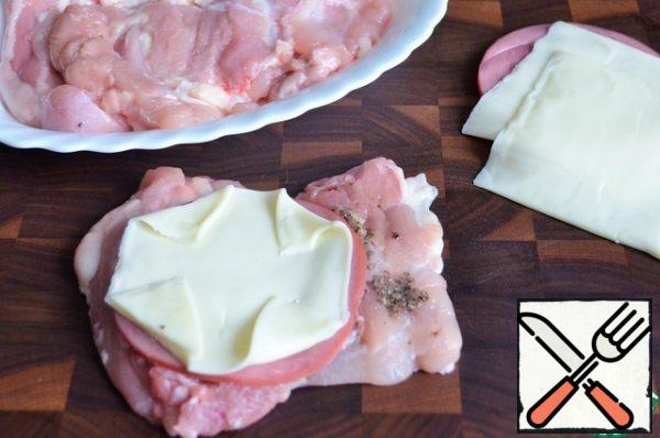Mix the crushed garlic and basil salt, rub the chicken with this mixture, add a slice of ham and a slice of cheese.