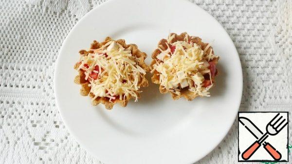 
We fill the tartlets, sprinkle with grated cheese and put in the oven for 5-10 minutes.

