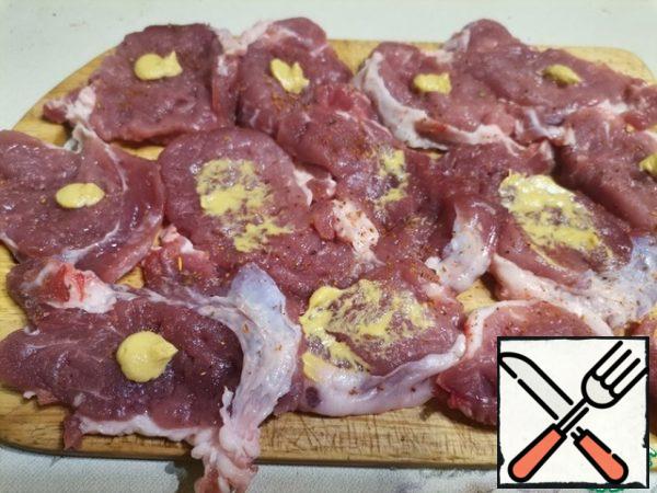 Apply mustard to each piece of meat and distribute it over the entire surface. Then we turn the pieces over and do the same on the other side. The mustard will not only give the meat a spicy taste, but also soften it.