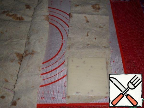 Cut the pita bread into strips, a little more than a slice of cheese in width.