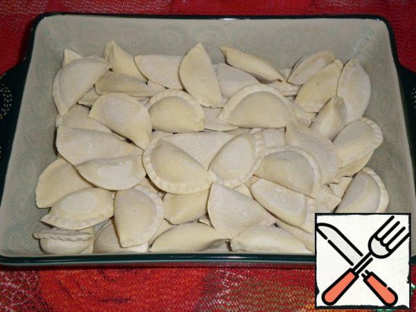 
Let's prepare the products. We turn on the oven for heating.
For the casserole, I will use pre-made homemade dumplings with minced chicken, they are frozen. Put the dumplings in a deep baking dish. We distribute evenly.