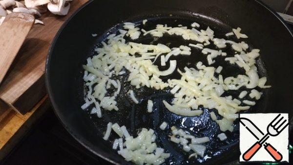 For the sauce, peel the onion and finely chop it. Cut the mushrooms into halves or quarters. Melt 20 g of butter in a frying pan and lightly brown the onion.