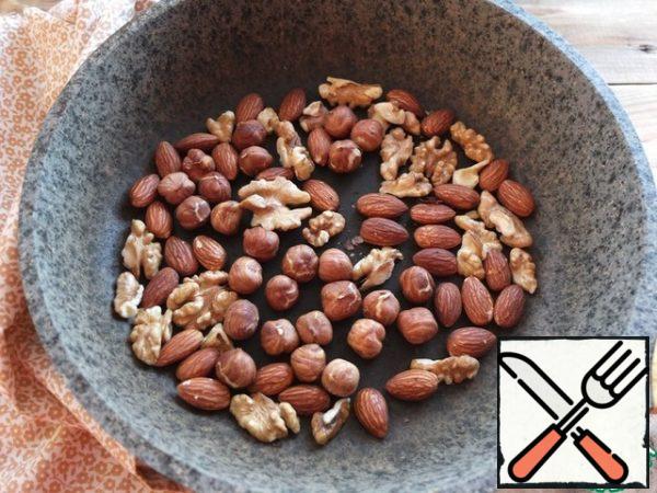 To prepare a dessert, it is better to take a saucepan with a thick bottom, so that the heating is uniform and the dishes keep the heat well.
We take the butter out of the refrigerator in advance and cut it into small squares.
Nuts, any to your taste, lightly fry in a frying pan and grind in a blender.
I took walnuts, almonds and hazelnuts.
