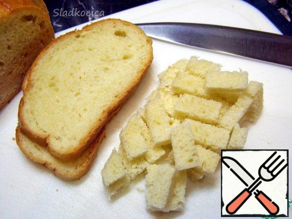 For the salad, you need crackers: you can take ready-made store-bought ones, but I prefer to make them myself. It's not difficult. Cut 5-6 slices from the loaf, cut off the crust and cut into small cubes. Put the bread cubes in a deep container or plastic bag, lightly sprinkle with vegetable oil and mix. Add salt, if desired, sprinkle with garlic powder (or other spices to your taste) and mix again.