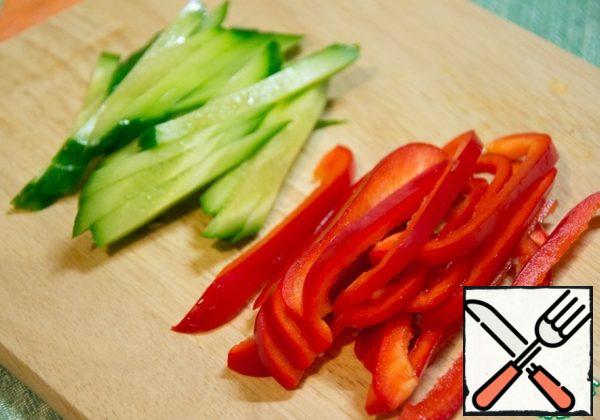 Cut the cucumber and pepper into strips.