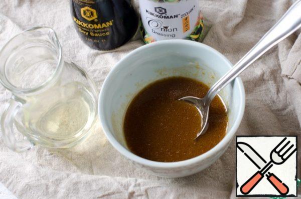 Now we turn to the preparation of the dressing. In a bowl, pour vegetable oil, soy sauce and salad sauce with onions, mix well.