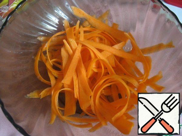 Cut the carrots into strips using a vegetable peeler.