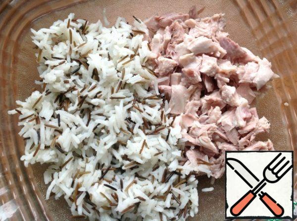 In a salad bowl, cut the boiled chicken fillet, add the finished rice.