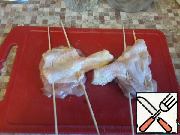 We string it on skewers so that the fan retains its shape when frying .