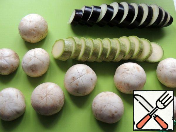 Mushrooms and vegetables are washed, we cut off the legs of the mushrooms.
We make incisions in the form of "snowflakes" on each hat, thanks to this they are marinated better. Vegetables cut into circles 1-1. 5 cm thick.