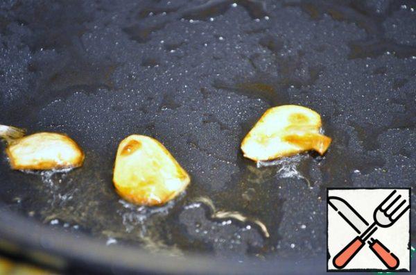 In olive oil, fry the garlic and remove it. I pour in the mushroom broth. I'll boil it and add the cream. Salt, add rosemary and basil.