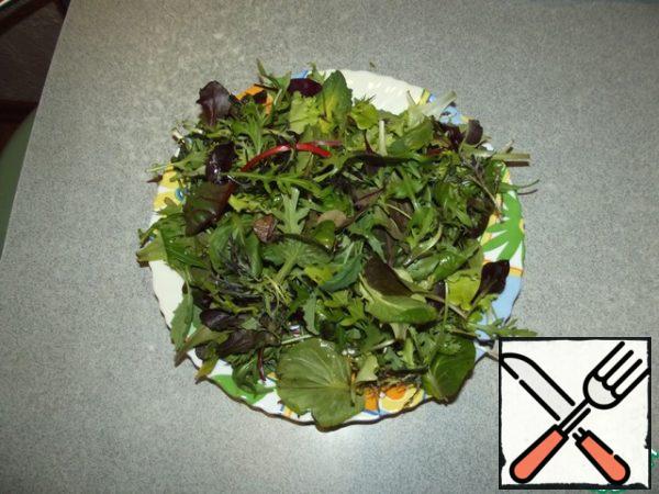 Wash the lettuce leaves, dry them, and put them on a platter.
Add the strips of bacon, mix.
