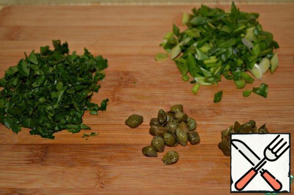Chop the parsley and onion. Cut the capers in half or into 4 pieces, if they are large.