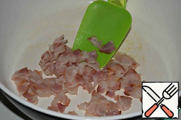 Cut the bacon slices into small pieces, put them in a slightly hot frying pan and fry for 5-6 minutes.
