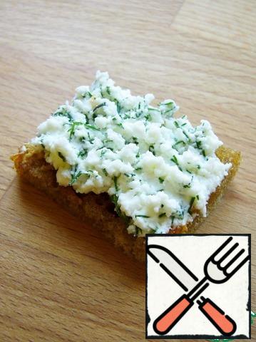 Spread a generous amount of feta with dill on the bread fried in garlic oil.