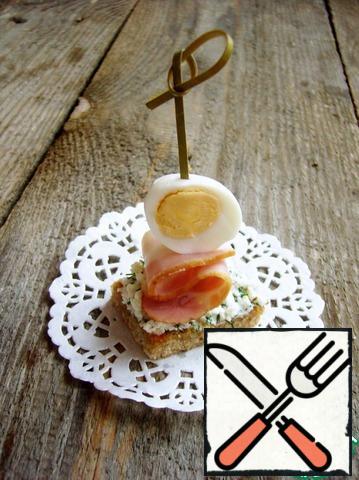 We string the egg and bacon on a skewer. We fix everything on the greased feta bread. It turned out to be a very tasty and easy-to-prepare snack.