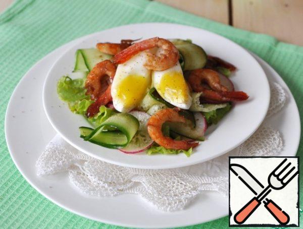 On top of the vegetables, put the shrimp, pour the fragrant oil from the pan.
Put the eggs in cold water, bring to a boil and cook for 4 minutes, so that the yolk remains liquid.
Decorate the salad with quarters of boiled egg, sprinkle with freshly ground pepper mixture, and serve immediately.