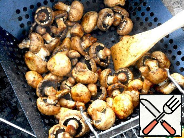 Fry the mushrooms in a grill pan, stirring them periodically with a spatula.