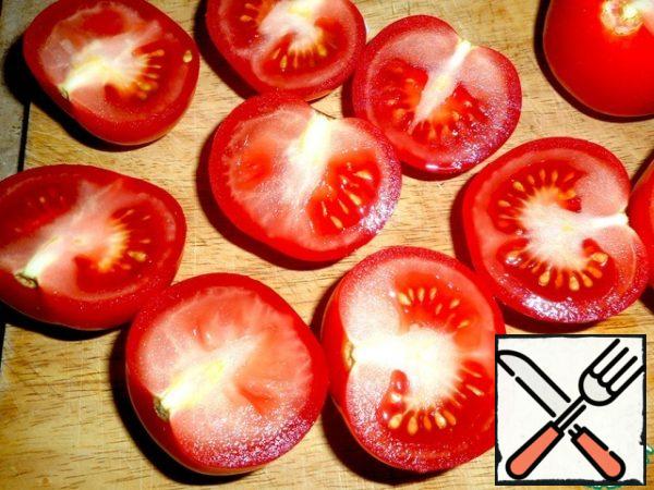 Tomatoes are washed and cut in half.