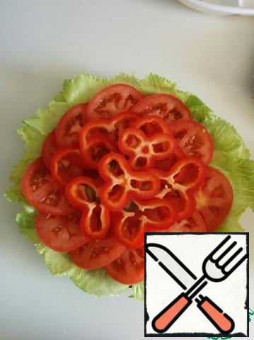 Put the lettuce, tomato, and pepper on a plate.