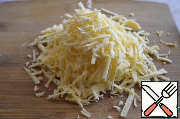 Grate the cheese on a grater.