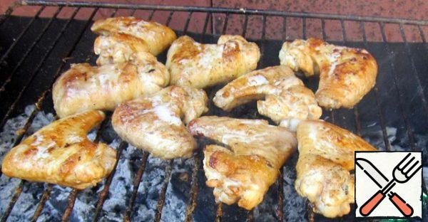 Cook the wings on the grill, on a low heat, browning on both sides, until tender.