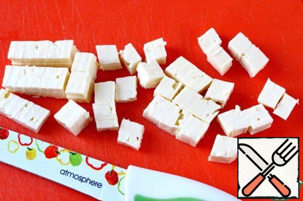 Cut the cheese into small cubes.
You can take any cheese for this salad, to your taste. It can be Serbian, Fetaki, or Bulgarian, with the only clarification: the cheese should not be too salty. You need to choose varieties that are more neutral in taste. I used Bulgarian lightly salted cheese, because it does not break up when mixed and retains the shape of a cube.