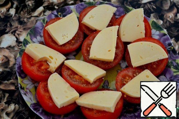 Tomatoes sprinkle with salt  (if you do not have enough salinity of soy sauce), sprinkle with sugar, season liberally with peppers.
Top with slices of cheese.