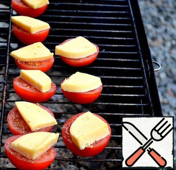 Bake tomatoes. We wait for the moment of softening of the cheese, it should not flow.