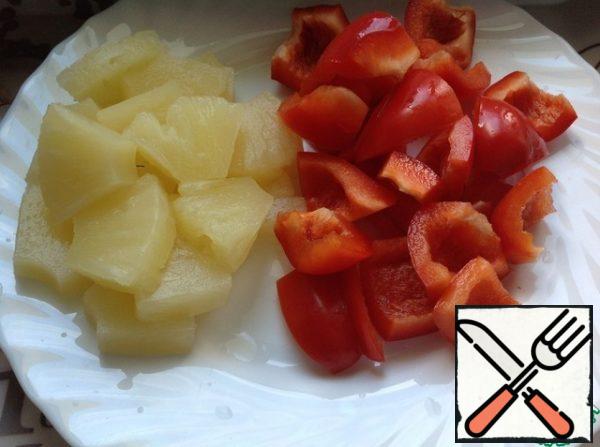 Cut the pineapple into large slices. Peel the peppers and cut them into slices.