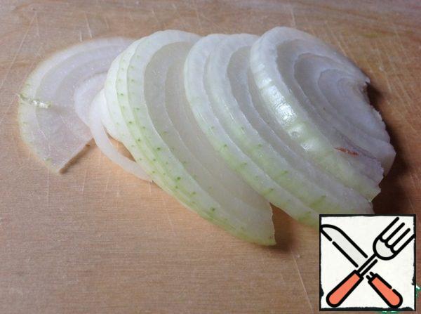Peel the onion and cut it into thin half-rings.
