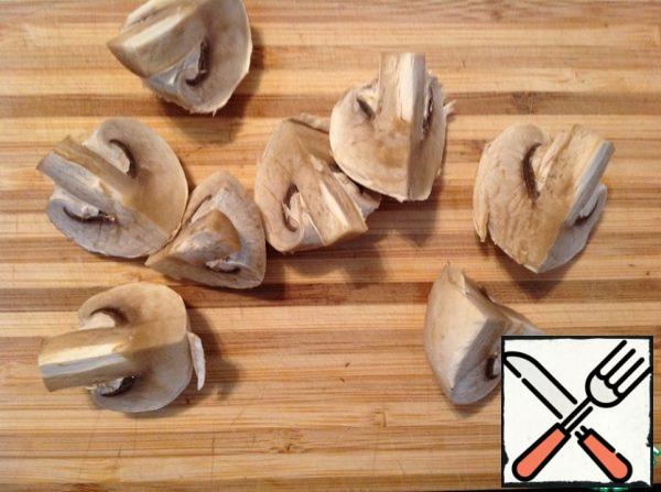 Wipe the mushrooms with a napkin, cut into 4 parts.