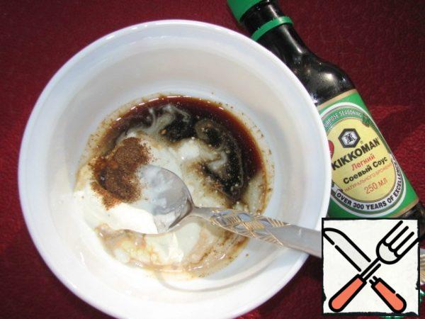 Prepare the marinade: mix 2 tablespoons of soy sauce, 2 tablespoons of sour cream and spices.