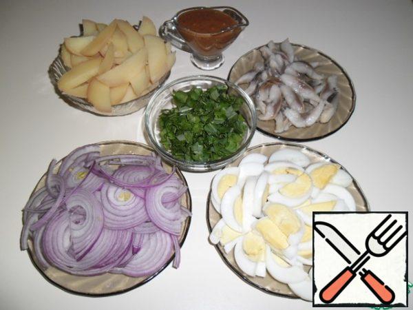 Peel the cooled potatoes and eggs and cut them into slices, half-ring the onion, and coarsely chop the arugula. Cut the herring fillet into strips.