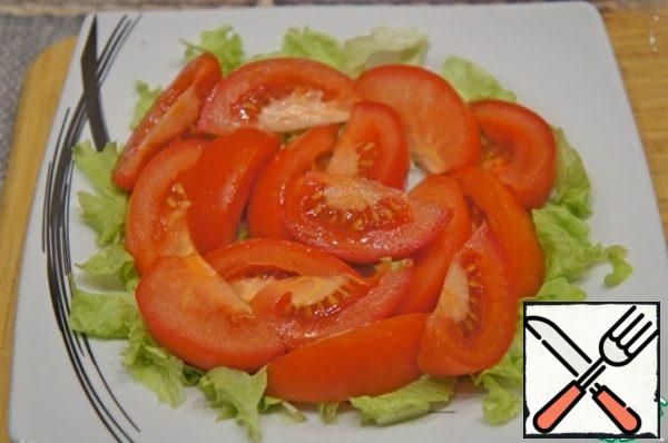 Cut the green lettuce leaves into small pieces and cover them with a flat dish. You can use the top of the Peking cabbage leaves. Cut the tomatoes into large slices and put them on the salad.