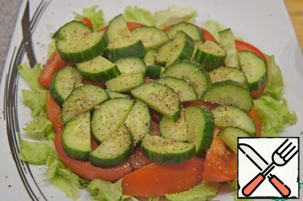 Cut the cucumber into half-rings 0.5 cm thick, put on top of the tomatoes. Add salt and pepper with a freshly ground pepper mixture to taste.