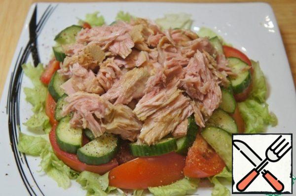 Remove the tuna meat from the brine, divide it into small pieces with a fork and place it on the vegetables.