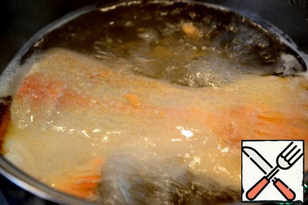 Boil the trout tail in a pot of water. Add spices, herbs. The finished fish is cleaned from the bones and disassembled into pieces for salad.