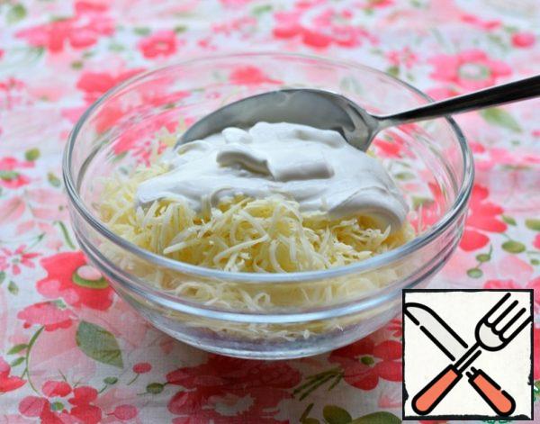Mix the grated cheese with sour cream (the remaining 50 g).