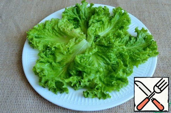 Wash the salad leaves, dry them and put them on a serving dish.